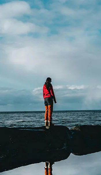Woman standing in a stone near ocean