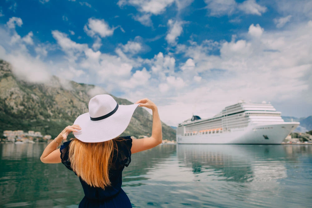 woman in hat stands on cruise liner background, rear view