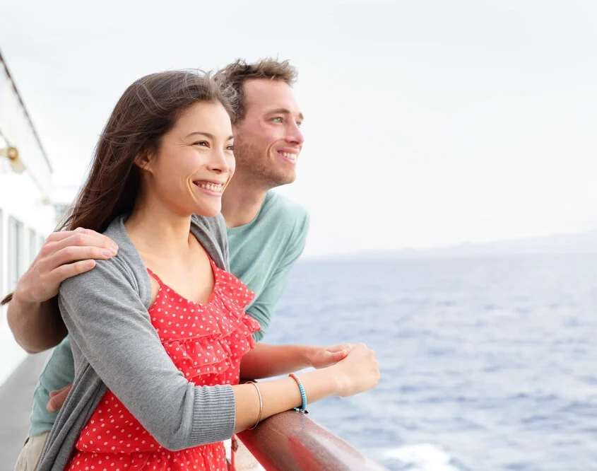 Romantic happy couple on cruise ship on boat travel embracing looking at view.