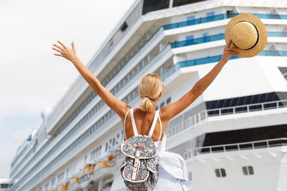 Woman tourist standing in front of big cruise liner, travel female